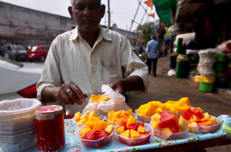 Na snímke predavač pripravuje ovocie na predaj na trhovisku v indickom meste Gauhátí.
