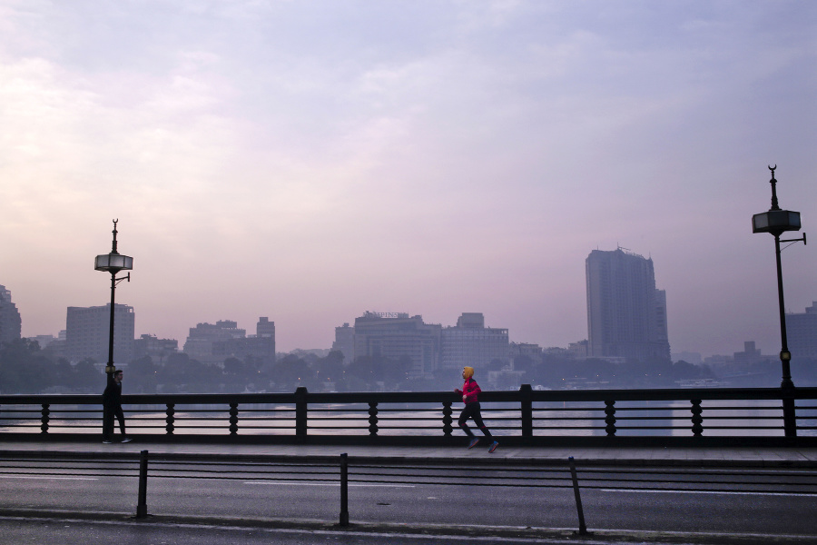 Muž behá po moste Kasr El Nil.