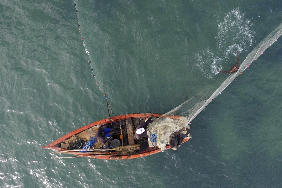 Haitskí rybári nahadzujú sieť v zálive v metropole Port-au-Prince.