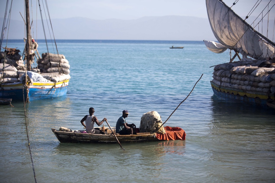 Rybári sa plavia okolo lode s drevným uhlím v Port-au-Prince.
