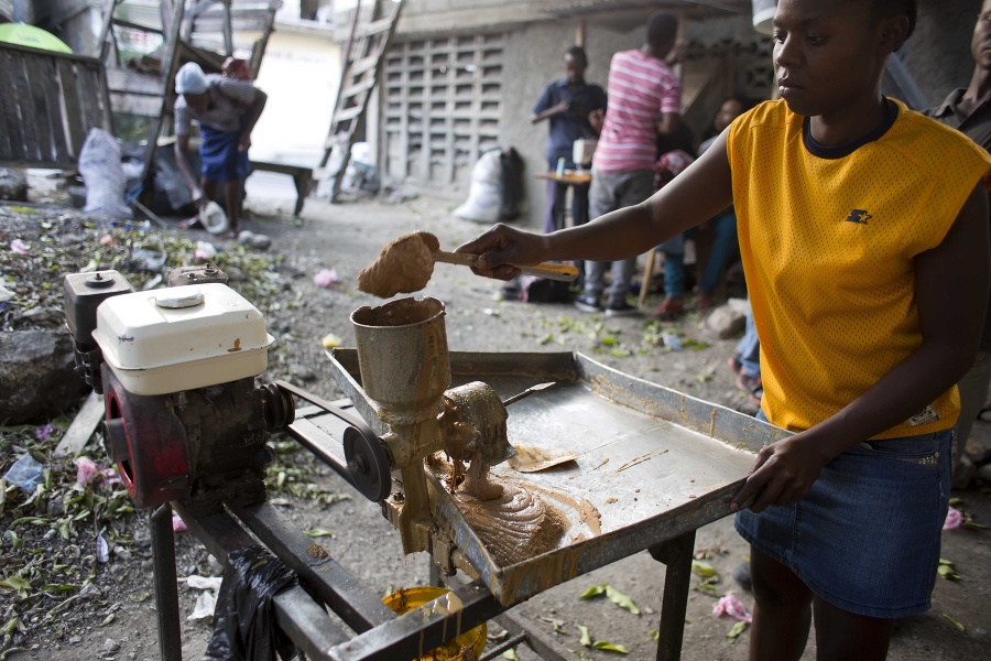 Žena vyrába arašidové maslo v Petion-Ville.