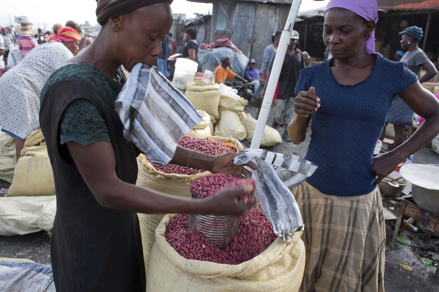 Predavačka predáva arašidy na trhu v Port-au-Prince.