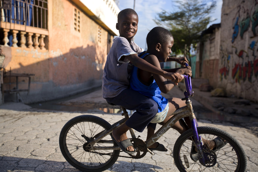 Kamaráti na bicykli v slume Cite Soleil v Port-au-Prince