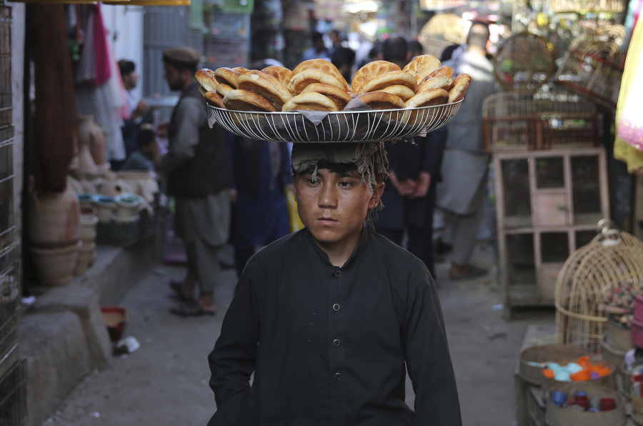 Afganský chlapec nesie na hlave košík s chlebom na predaj na trhu v starej časti mesta Kábul.