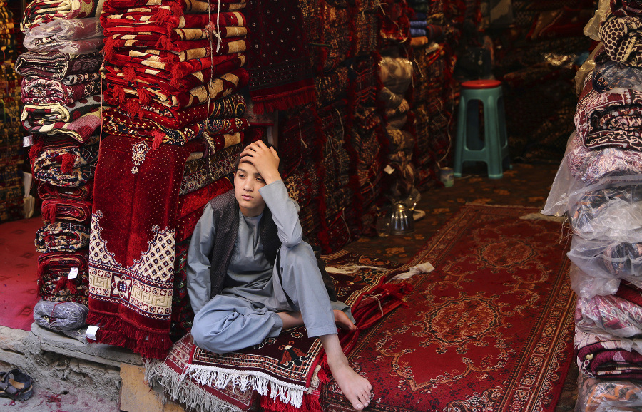 Afganský chlapec čaká na zákazníkov v obcode s kobercami v Kábule.