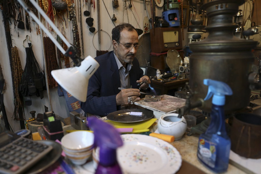 Zlatník opravuje prsteň vo svojom obchode v štvrti na juhu Teheránu, v ktorej žije iracká komunita.
