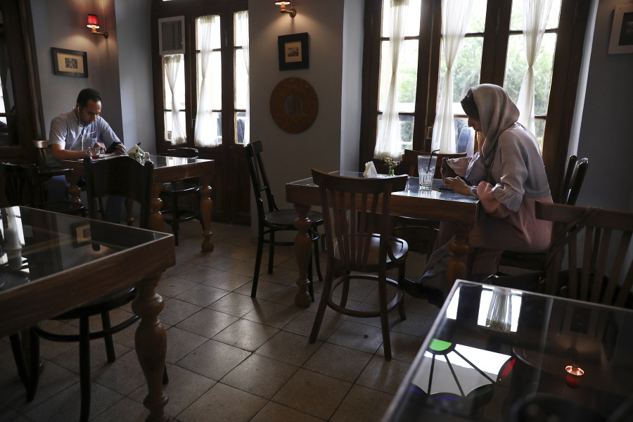 Muž a žena trávia popoludnie v kaviarni v Teheráne.
