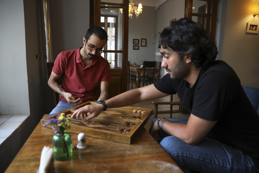 Dvaja muži hrajú spoločenskú hru  v kaviarni v centre Teheránu.
