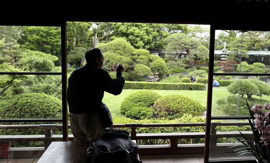 Návštevník fotografuje japonskú záhradu v chráme Taišakuten Daikyoji v Tokiu.