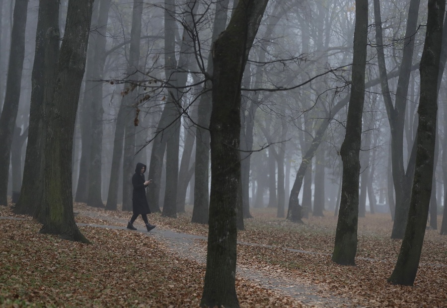 Žena kráča v parku v hmlistom jesennom ráne v bieloruskom Minsku. © SITA/AP