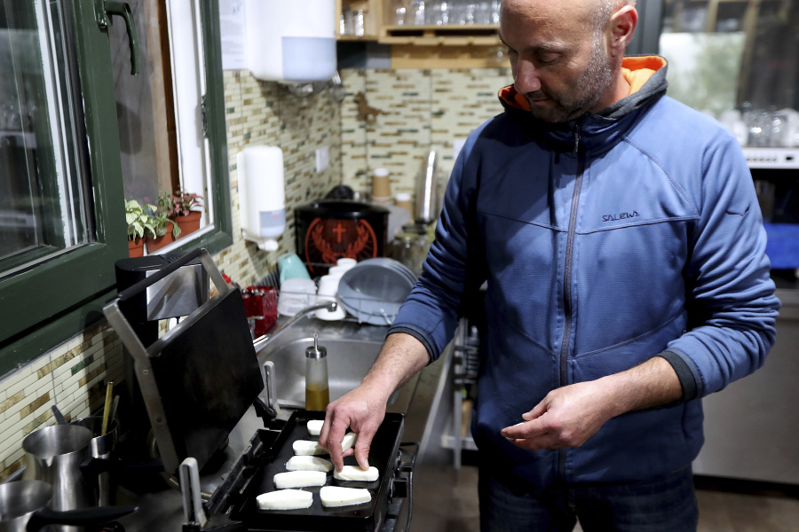 cyperský farmár 48-ročný Vasilis Kyprianu griluje tradičný cyperský polotvrdý slaný syr halloumi.