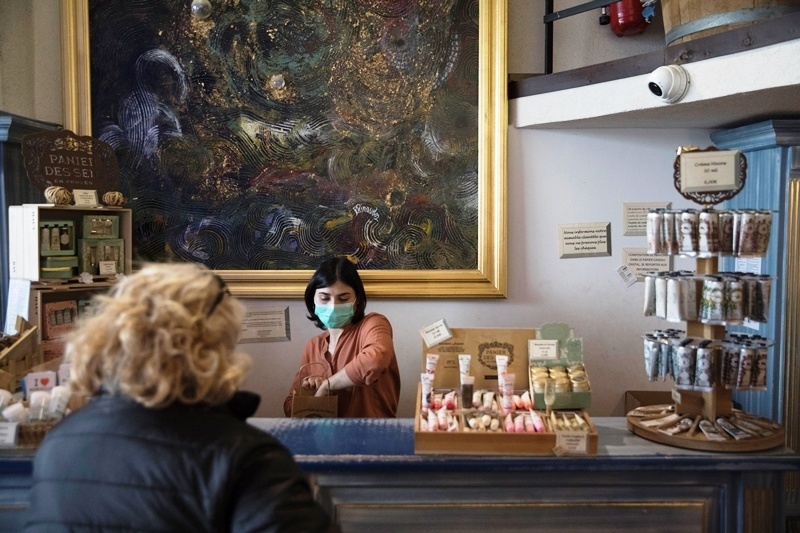 Julie Dinotová s ochranným rúškom obsluhuje zákazníčku v predajni mydiel Savonnerie Marseillaise de la Licorne.