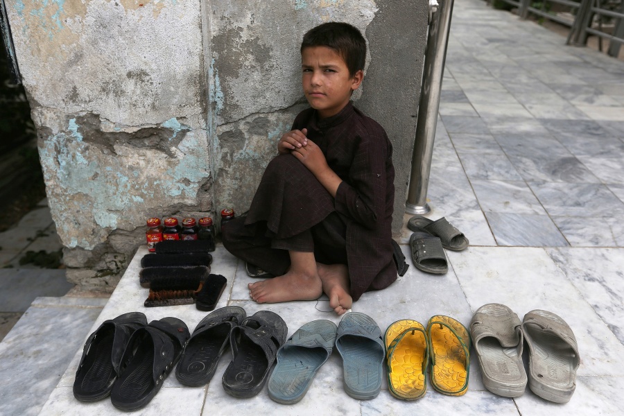 Malý čistič topánok čaká na zákazníkov na ulici v Kábule.