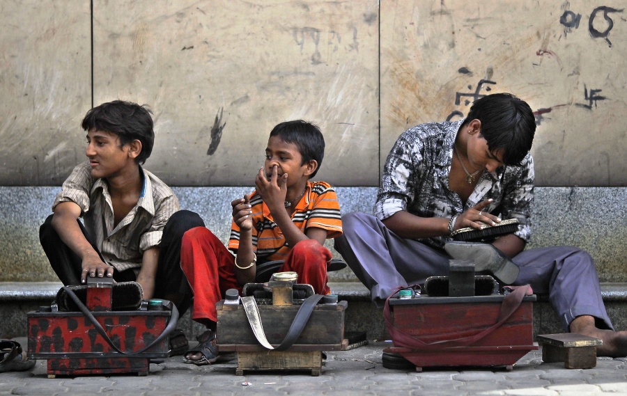 Malí čističi topánok čakajú na zákazníkov na ulici v indickom meste Naí Dillí.