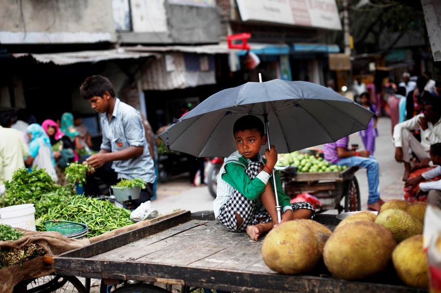 Chlapec predáva zemiaky počas dažďa v Naí Dillí.