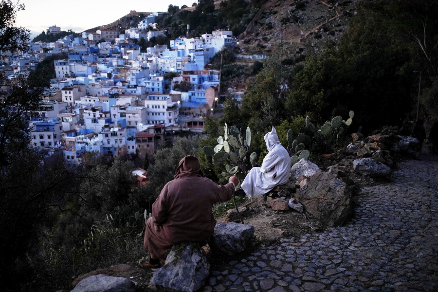 Dvaja muži sedia na kopci a pozerajú sa na mesto Šafšawán.