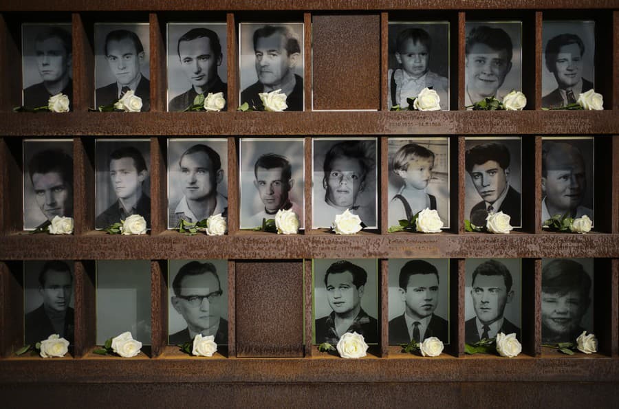 Biele ruže položené pred fotografiami obetí na pamätníku Berlínskeho múru