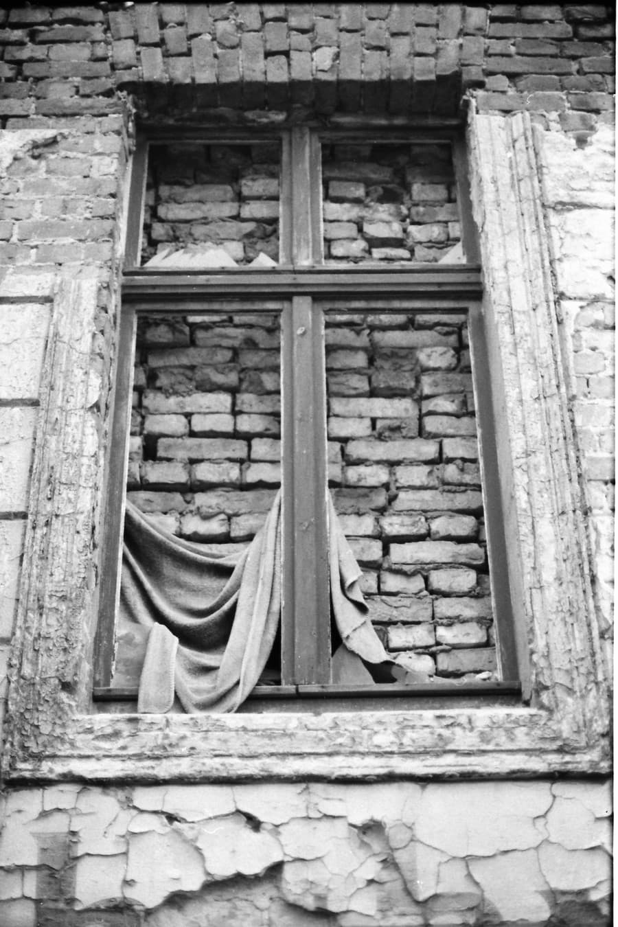 Na snímke z 21. marca 1978 zamurované okno v suteréne obytnej budovy na Bernauerskej ulici, ktoré tvorí hranicu medzi Západným a Východným Berlínom, a je súčasťou Berlínskeho múru.