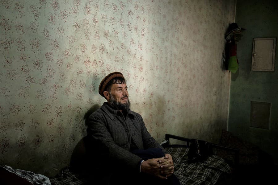 Abdul Fatah sedí na posteli v kine Ariana v Kábule. Fatah žije v kine, kde pracuje ako bezpečnostný pracovník.