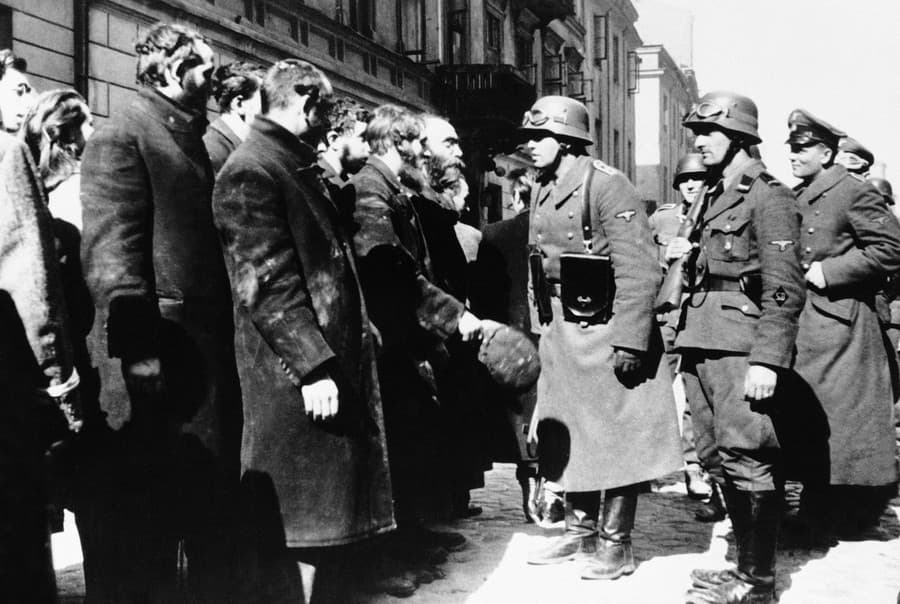Na archívnej snímke z roku 1943 nacistickí dôstojníci sa rozprávajú s obyvateľmi Varšavy.
