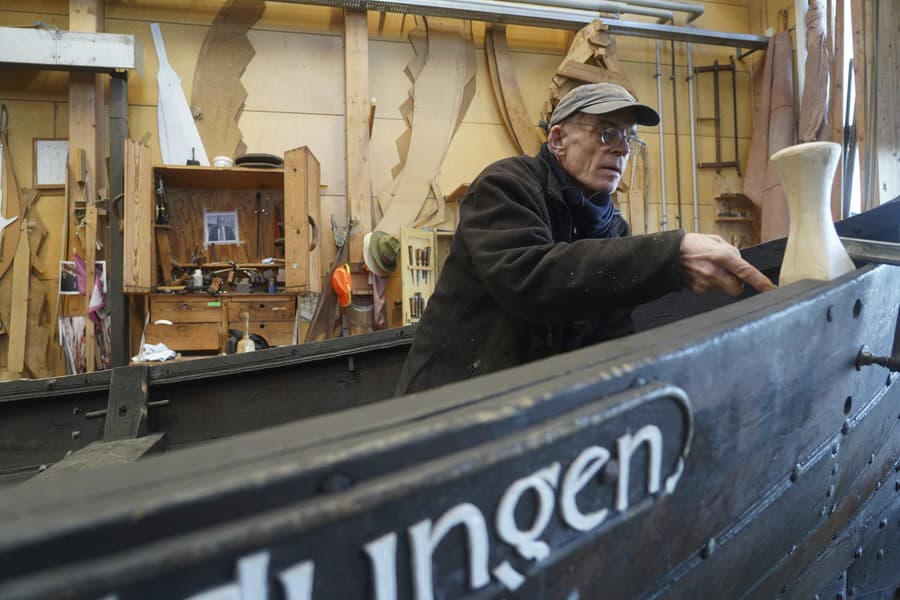 Muž opravuje desať metrov dlhý drevený čln zhotovený tradičnou severskou technikou tzv. 