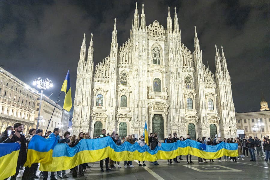 Ľudia držia veľkú ukrajinskú vlajku pred katedrálou v talianskom Miláne