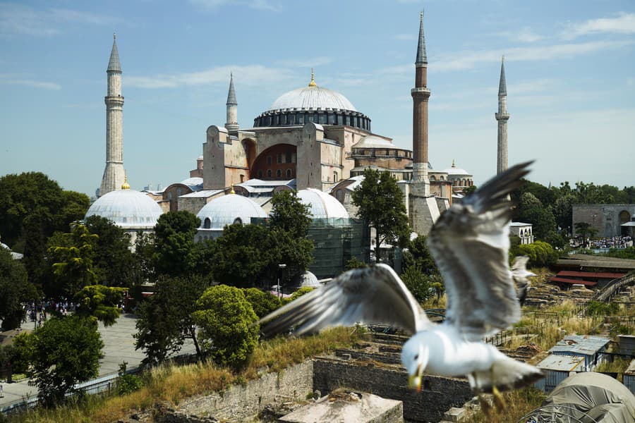 Čajka uchmatla kúsok syra od turistu neďaleko bývalýého byzantského kresťanského chrámu, neskôr tureckej moslimskej mešity Hagia Sophia v Istanbule v Turecku.