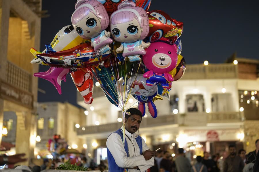 Pouličný predavač predáva balóny na trhu Souq Waqif.