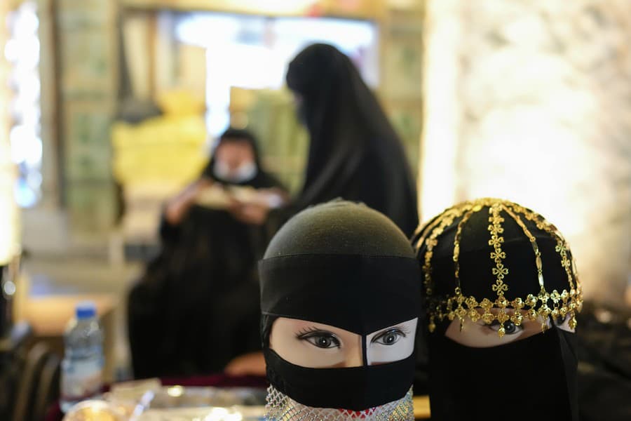 Pouličný predavač predáva dámske oblečenie na trhu Souq Waqif.