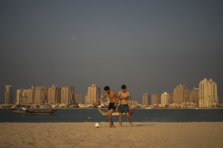 Muži hrajú futbal na pláži Katara.