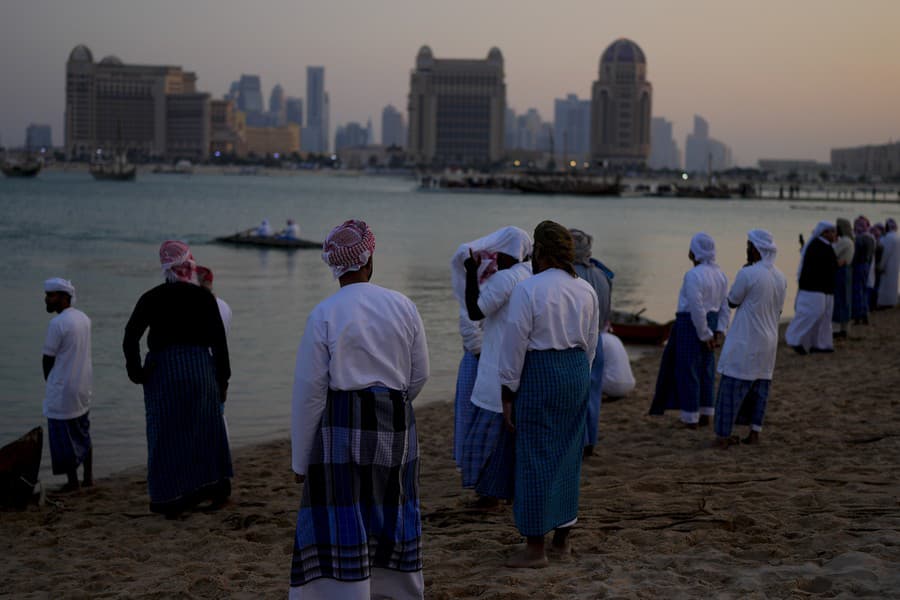 Muži stoja na pláži Katara v Dauhe.