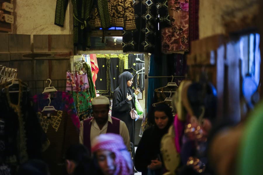 Žena hľadá tovar na trhu Souq Waqif.