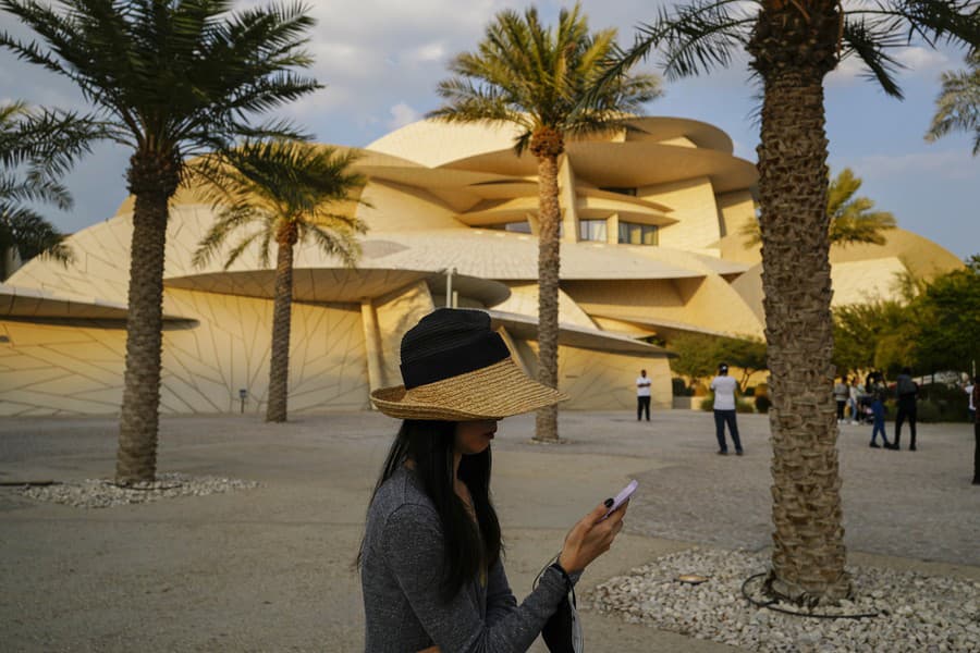 Žena kráča pred Národným múzeom Kataru.