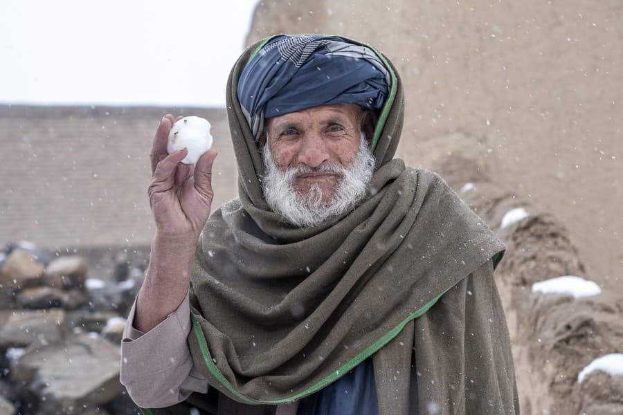 Afganský starček hádže snehovú guľu