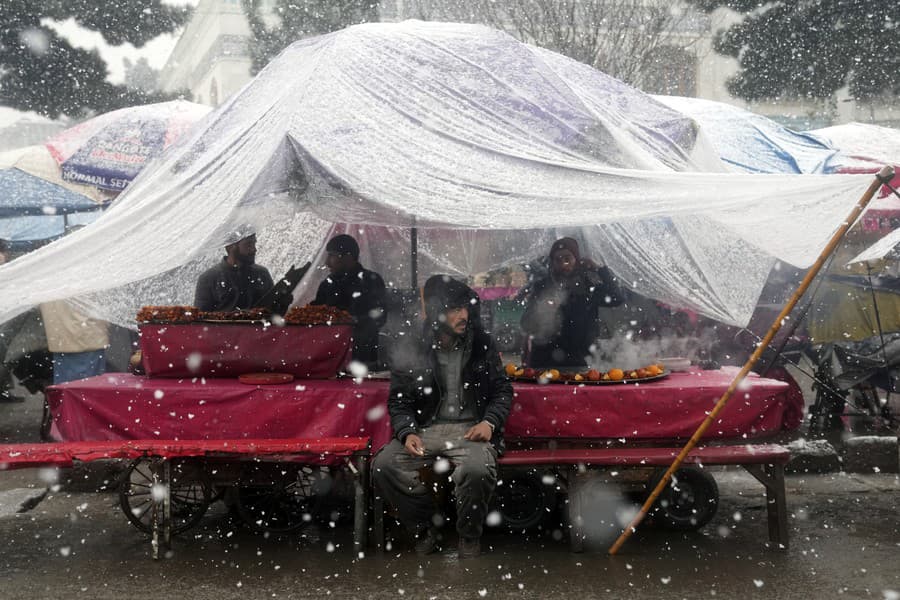Pouličný predavač ovocia čaká na zákazníkov v hustom snežení v Kábule