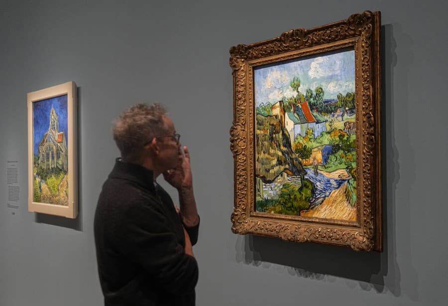 Muž sa pozerá na olejomaľbu od Vincenta Van Gogha s názvom Dom  v Auvers-sur-Oise z roku 1890