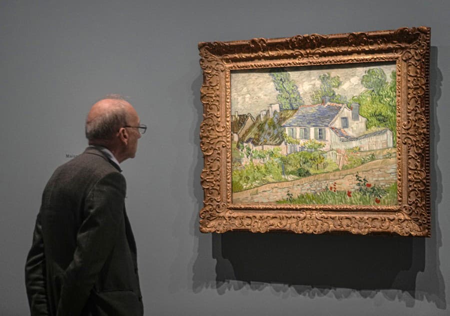 Muž sa pozerá na olejomaľbu od Vincenta Van Gogha s názvom Dom  v Auvers-sur-Oise