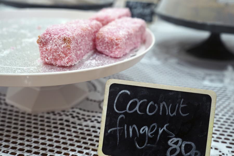 Kokosové prsty, tradičný dezert vyrobený z piškótovej torty a posypaný kokosom