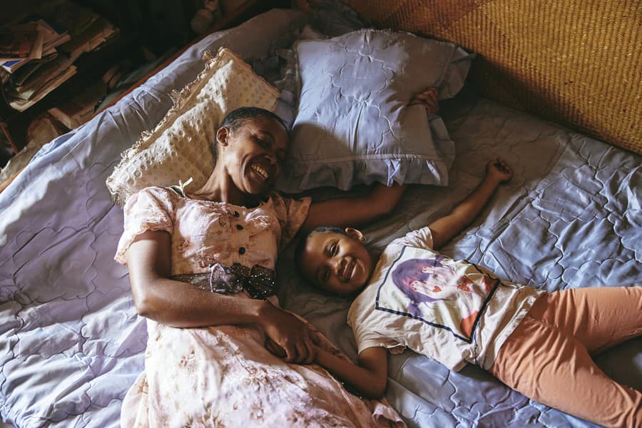Fara a jej dcéra Odliatemix spolu ležia na posteli, o ktorú sa delia s Dada Paulom. Fara sa sama stará o trojčlennú rodinu. Len jedna organizácia na Madagaskare, Masoandro Mody, poskytuje podporu a školenia rodinným príslušníkom ľudí s demenciou. Antananarivo, Madagaskar, 12. marca 2023.