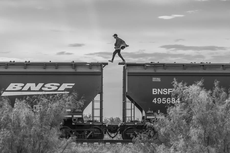 Migrant kráča na vrchole nákladného vlaku známeho ako „La Bestia“. Migranti a žiadatelia o azyl, ktorým chýbajú finančné zdroje na zaplatenie pašeráka, sa často uchyľujú k použitiu nákladných vlakov, aby sa dostali na hranicu Spojených štátov. Tento spôsob dopravy je veľmi nebezpečný; v priebehu rokov stovky ľudí spadli na koľaje a zomreli alebo zostali zmrzačení. Piedras Negras, Mexiko, 8. októbra 2023.