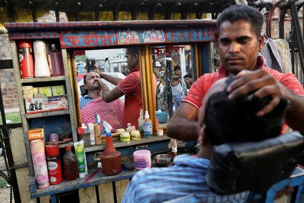 Indický pouličný holič utiera