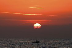 Rybár počas západu Slnka na Stredozemnom mori