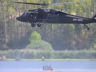 Vrtuľník Black Hawk UH-60 naberá vodu v priehrade, ktorú použije na hasenie požiaru