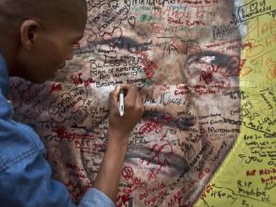 Plagát Nelsona Mandelu s odkazmi od jeho priaznivcov visí na ulici neďaleko jeho starého domu v Johannesburgu.