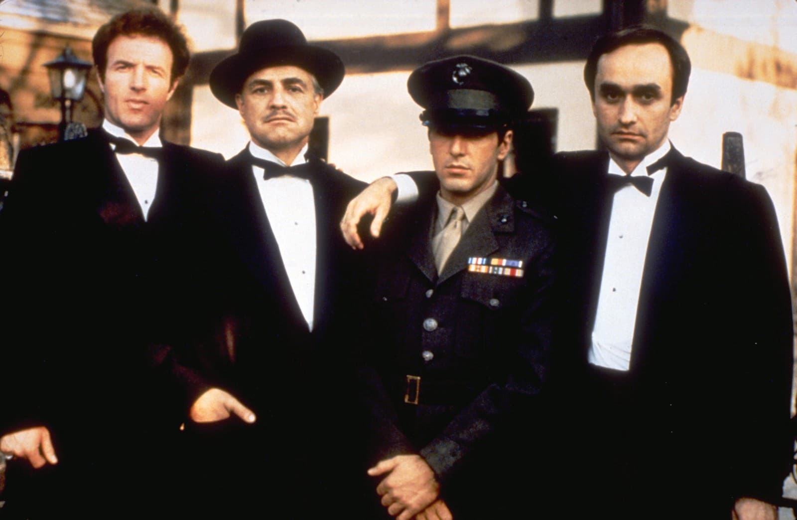 Zľava James Caan ako Sonny Corleone, Marlon Brando ako Don Vito Corleone, Al Pacino ako Michael Corleone a John Cazale ako Fredo Corleone vo filme Krstný otec (Zdroj: SITA/Paramount Pictures via AP)