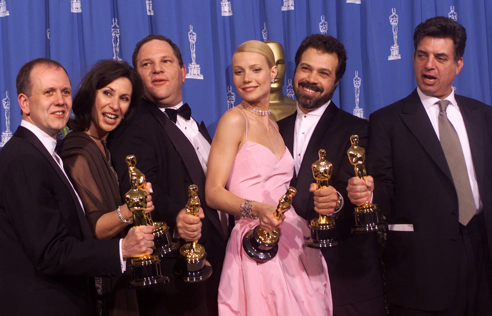 Zľava David Parfitt, Donna Gigliotti, Harvey Weinstein, Gwyneth Paltrow, Edward Zwick, Marc Norman pózujú v roku 1999 so soškami Oscara (Zdroj: SITA/AP Photo/Dave Caulkin, File)
