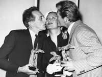 Jean Cocteau (vľavo) a francúzsky herec Jean Marais bozkávajú francúzsku herečku Michele Morganovú po prevzatí ceny na filmovom festivale v Cannes