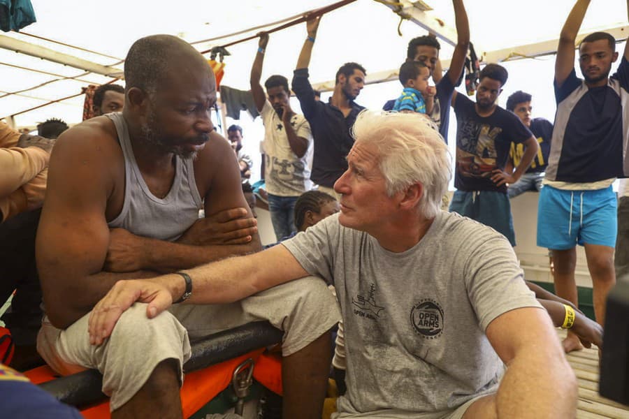Archívna snímka z roku 2019, Richard Gere sa rozpráva s migrantom (Zdroj: TASR/AP Photo/Valerio Nicolosi).