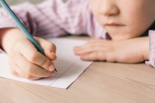 Little caucasian boy writing