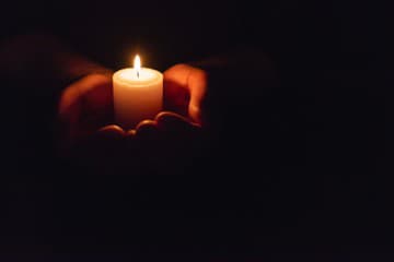 Hands holding burning candle